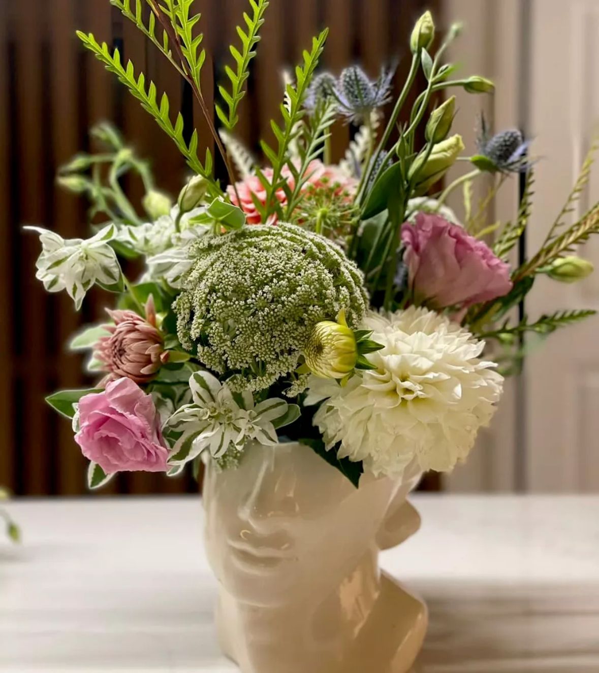 Champagne bottle floral arrangement with gold balloon